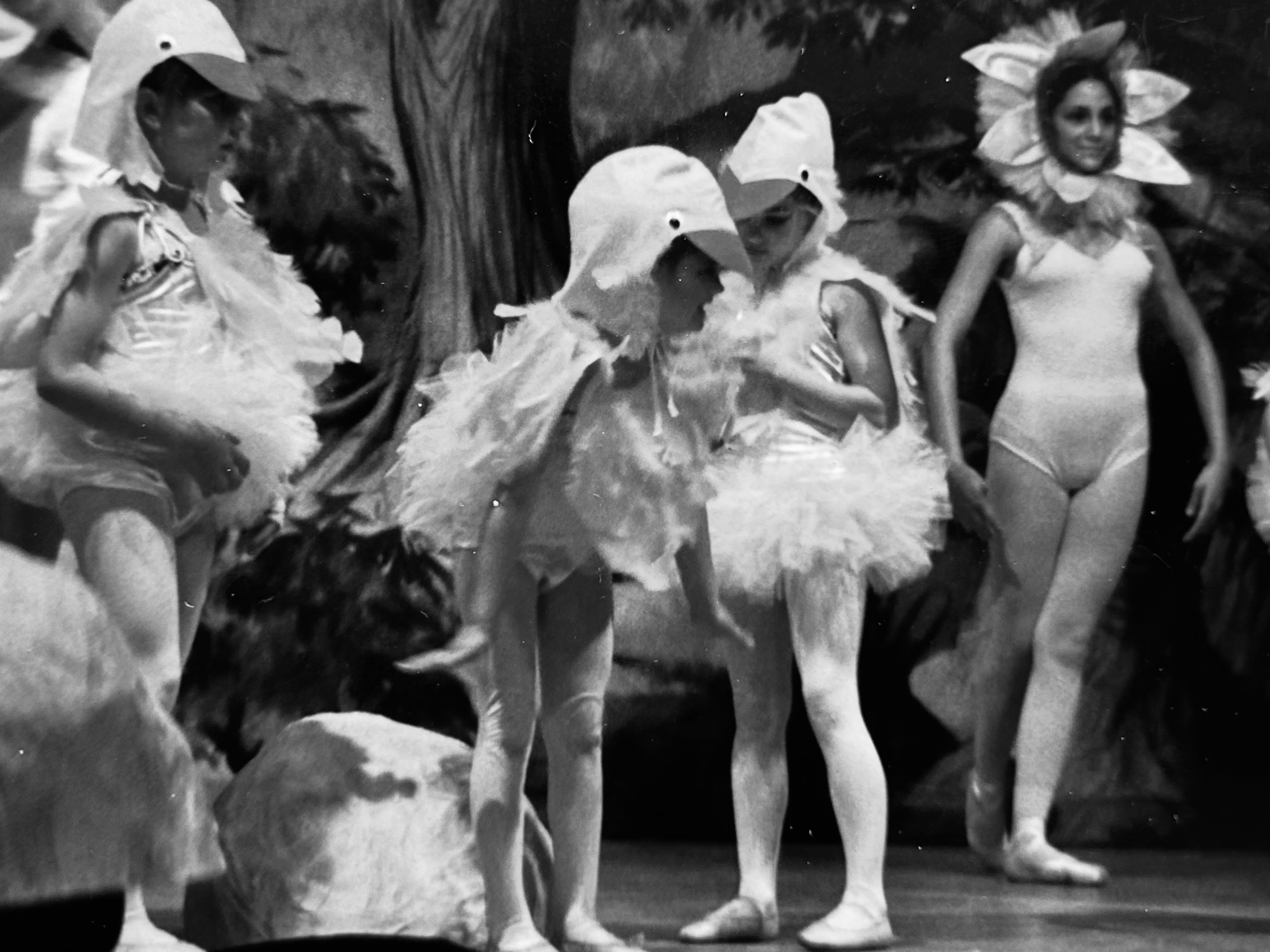 Young girls in ballet costumes on stage, vintage black and white photograph, faces softened